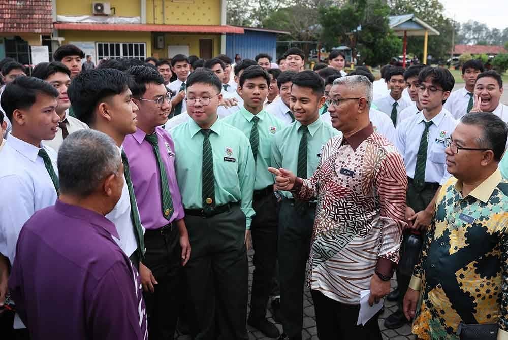 Pengarah Jabatan Pendidikan Negeri Terengganu Jelani Sulong (tiga, kanan) menyantuni calon-calon Sijil Pelajaran Malaysia (SPM) 2024 sebelum masuk ke dewan bagi menduduki peperiksaan bertulis Bahasa Melayu Kertas I di Sekolah Menengah Kebangsaan (SMK) Sultan Sulaiman dekat Kuala Terengganu hari ini. 