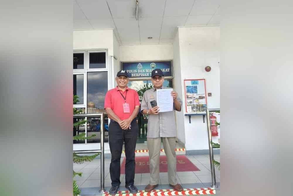 Abdul Razak (kanan) membuat laporan polis terhadap dua individu yang membuat hantaran berunsur fitnah terhadap PM di Ibu Pejabat Polis Daerah (IPD) Manjung pada Khamis. Foto: ihsan pembaca