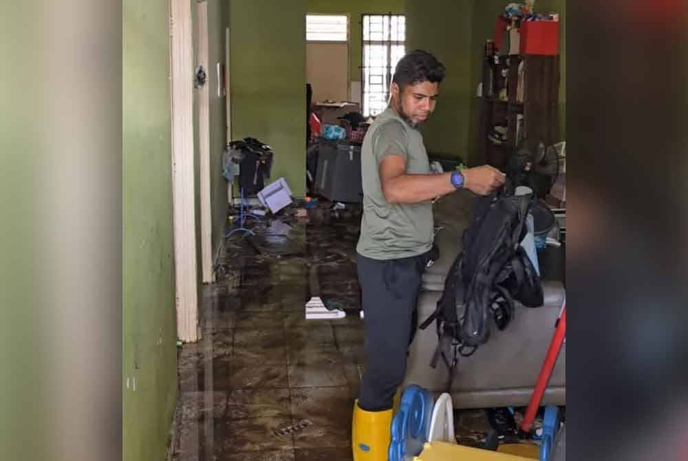 Penduduk membersihkan rumah selepas air surut.
