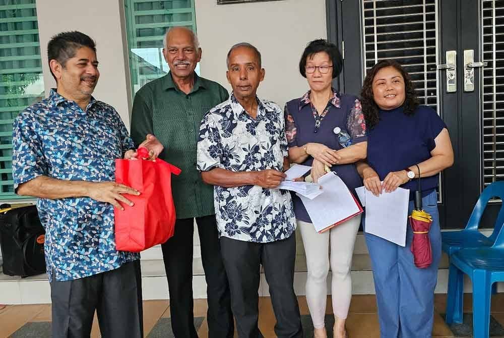 Kulasegaran (tengah) yang juga Ahli Parlimen Ipoh Barat menyampaikan bantuan kepada penduduk Arena Kepayang Putra, Fair Park yang terlibat dalam kejadian banjir pada 1 Disember lalu.