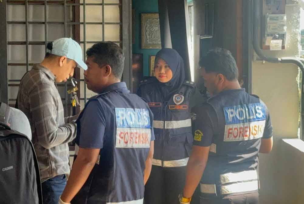 Anggota polis sedang menjalankan siasatan di rumah mangsa di Flat Jalan Perai Jaya selepas kejadian berlaku.