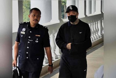 Yong Hua (kanan) yang memakai baju hitam, dibawa ke Mahkamah Sesyen Kuala Lumpur pada Jumaat, bagi menghadapi satu pertuduhan membuat hantaran jelik, tiga tahun lalu.