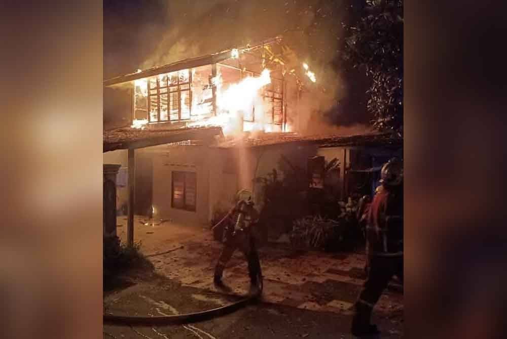 Anggota bomba cuba memadamkan kebakaran rumah berkenaan.Foto BBP Larkin