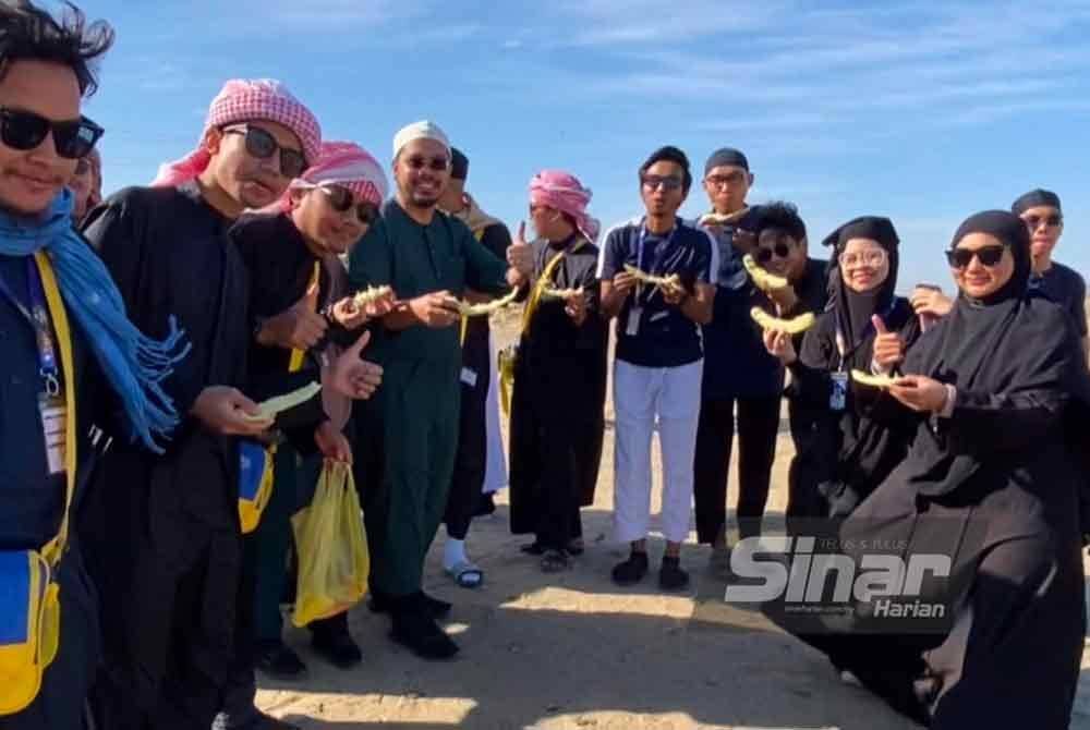Pengerusi Masjid Imanul Fa'izin, Leftenan Kol Bersekutu (PA) Nik Saiful Adli Burhan (empat, kiri) menikmati buah-buahan bersama peserta semasa porogram ziarah di ladang unta.