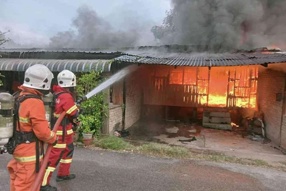 Anggota Bomba dan Penyelamat melaksanakan operasi memadam kebakaran di Kampung Keda Tanjung Dawai.