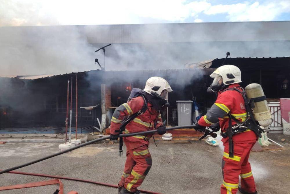Anggota bomba memadam kebakaran membabitkan lapan gerai makan di Taman Sri Puteri, Skudai. Foto JBPM