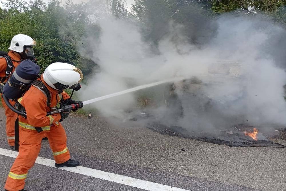 Anggota BBP Lenggong mengawal kebakaran sebuah kereta yang terbabas menyebabkan seorang mangsa cedera di Jalan Lenggong-Gerik berhampiran Kampung Baru Air Kala di sini pada Isnin. Foto JBPM Perak