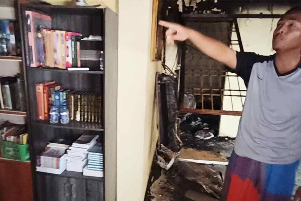Marhafiz menunjukkan rak yang menempatkan al -Quran dan tafsir hadis tidak dijilat api dalam kebakaran itu.
