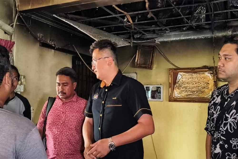 Seah Shoo Chin (tengah) ketika melihat ruang solat Surau Al Amin, Taman Limbongan Permai, di sini, terbakar pada awal pagi Isnin.