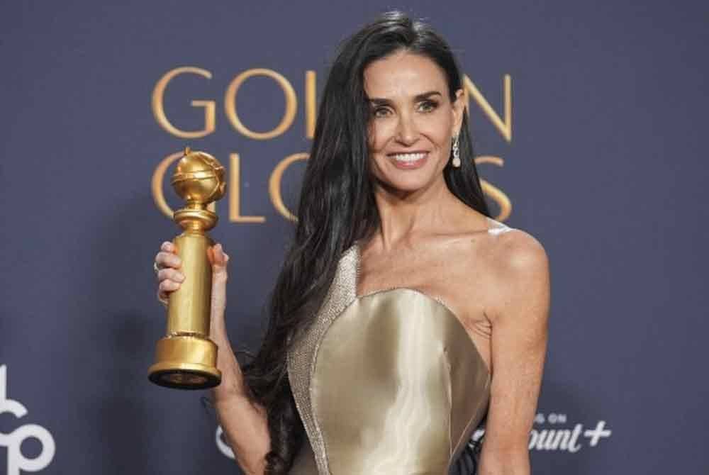 Demi Moore bersama anugerah pertamanya.