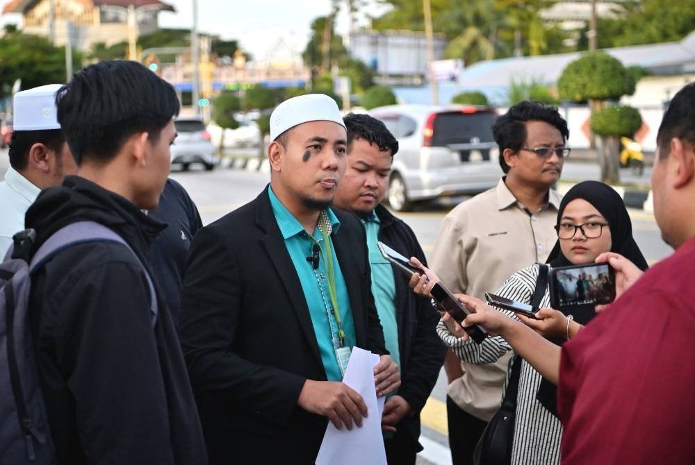 Muhammad Irsyad Syafiq (tengah) bersama wakil Pemuda Pas Terengganu ditemui pemberita selepas selesai membuat laporan di IPD Kuala Terengganu.