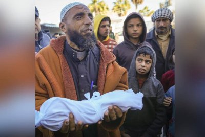 Imam Abu Suaied memegang jenazah Jomaa al-Batran yang meninggal dunia akibat hipotermia sebelum pengebumiannya di Gaza. Foto AP