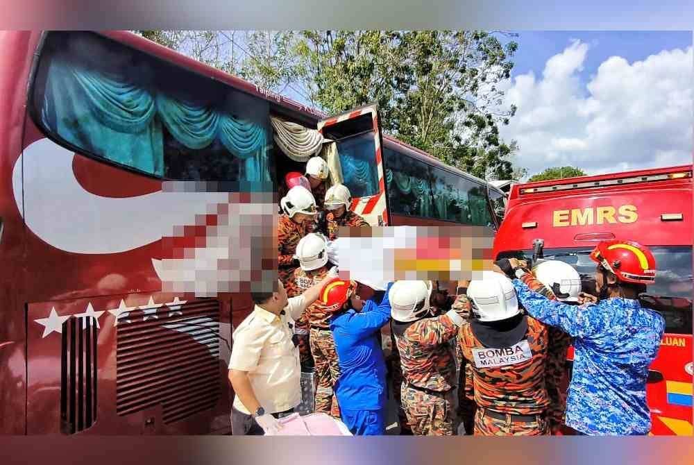 Pasukan penyelamat sedang menyelamatkan pemandu bas yang tersepit dalam kemalangan itu.