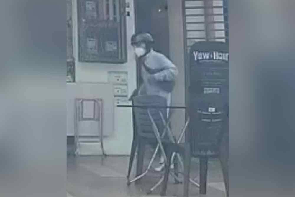 Tangkap layar gambar seorang lelaki yang memakai topi keledar dan berbaju biru muda serta memakai beg turut tular.