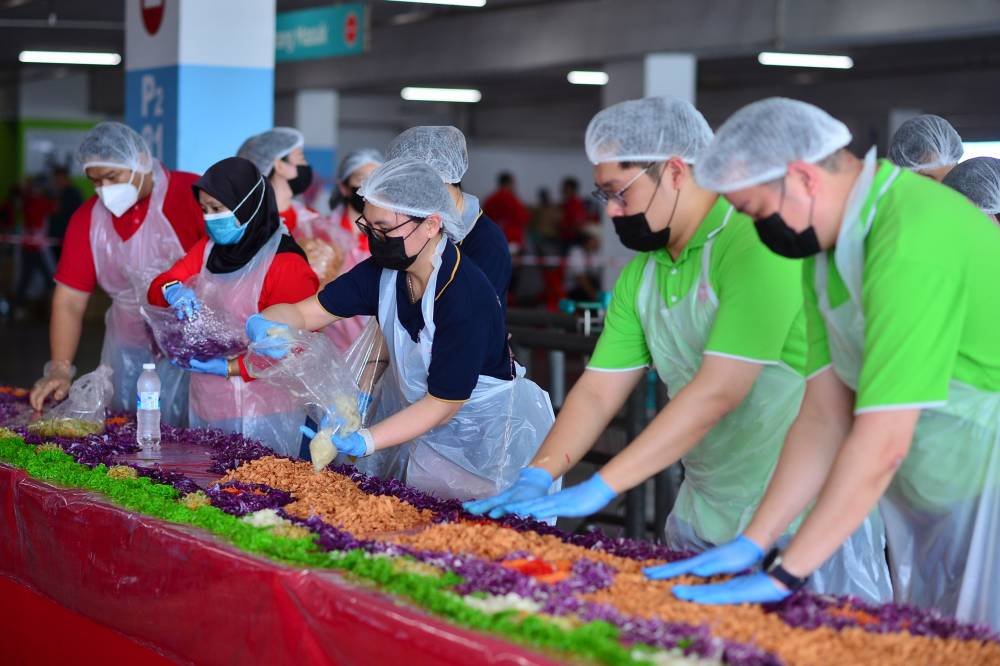 Antara sukarelawan yang hadir untuk menyiapkan yee sang sepanjang 1,211 meter.