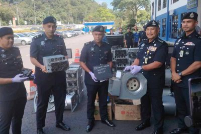 Norhizam (dua dari kanan) menunjukkan antara peralatan bitcoin yang dirampas menerusi serbuan di sekitar Sepang, pada Rabu.