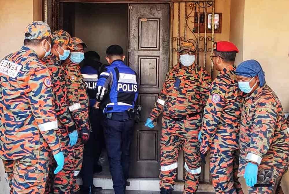 Anggota polis dan bomba memasuki rumah mangsa selepas dihubungi jirannya yang terhidu bau busuk.