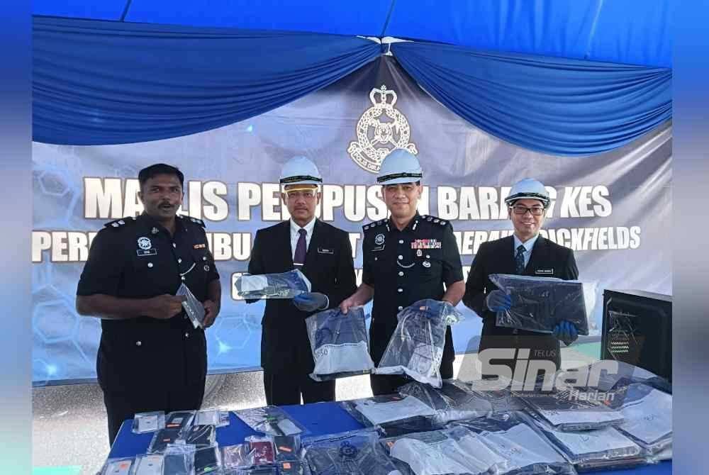 Ku Mashariman (dua dari kanan) bersama Mohd Sabri (kanan) dan Rosli (dua dari kiri) menunjukkan barang rampasan yang akan dilupuskan oleh IPD Brickfields pada Jumaat. Foto HISYAMUDDIN AYUB.