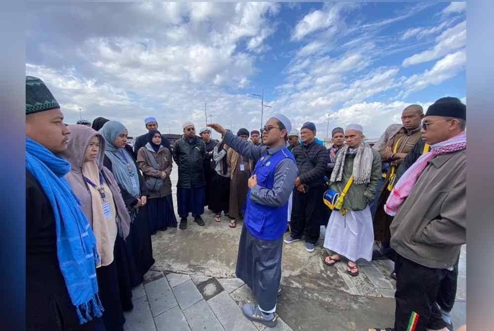 Ahmad Junaidi (tengah) menceritakan sejarah Bukit Uhud kepada para peserta Program Umrah Percuma Anak Muda Jati Kelantan.