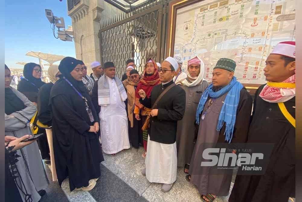 Ahmad Junaidi (tengah) memberi penerangan kepada peserta Program Umrah Percuma Anak Muda Jati Kelantan semasa sesi lawatan di sekitar Masjid Nabawi. FOTO SINAR HARIAN