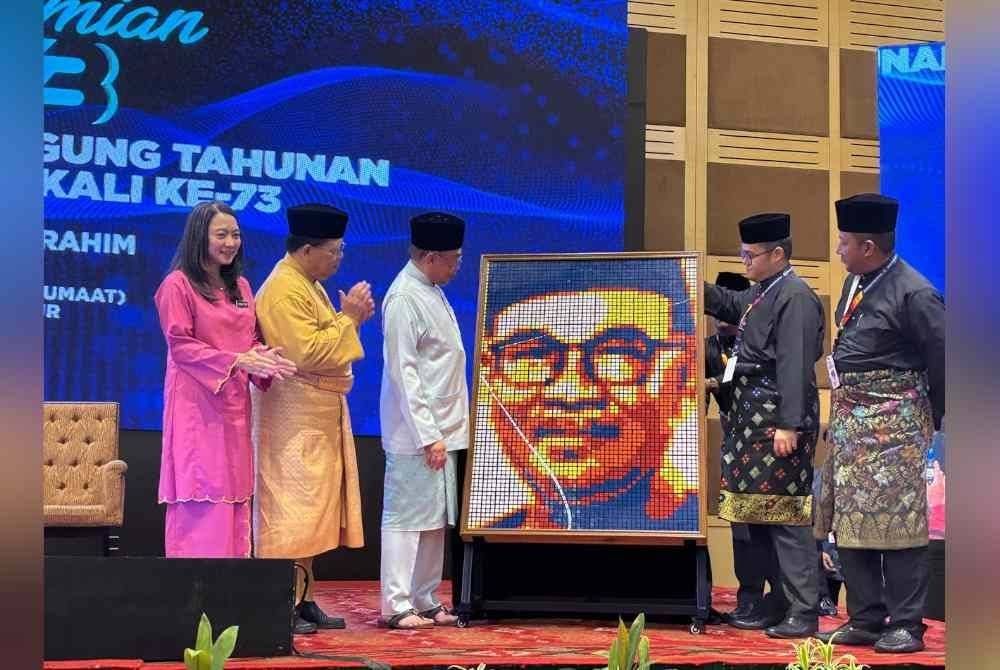 Hannah ( kiri), Johari, Anwar dan Mohd Izzat sewaktu penyerahan cenderahati ketika Majlis Perasmian Mesyuarat Perhimpunan Agung Tahunan (MPAT) ke-73 MBM pada Jumaat.