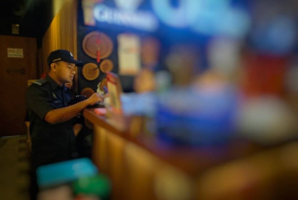 Pegawai KPDN sedang menjalankan pemeriksaan pematuhan terhadap penggunaan alat sukat cecair dan masa di sebuah premis perniagaan. Foto KPDN Pahang