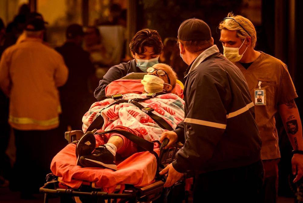 Anggota perubatan membawa keluar mangsa yang terbabit dalam kebakaran hutan Pasedena, California. AFP