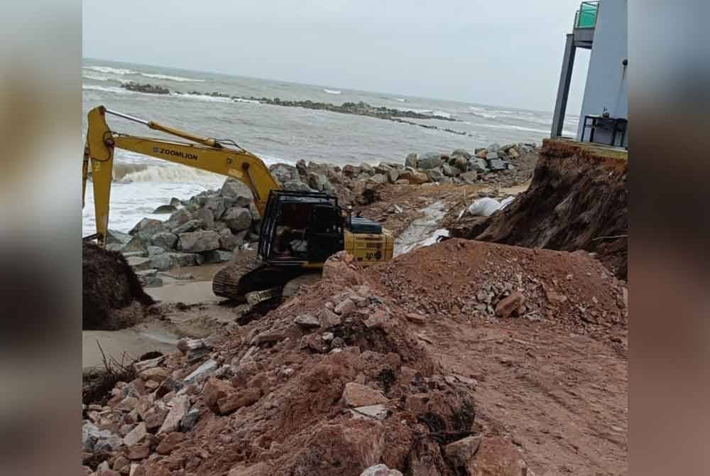 Proses membina benteng sementara sedang dijalankan bagi menyelamatkan sebuah rumah di Kampung Tanjung, Batu Rakit di Kuala Nerus bermula pagi Sabtu. Gambar: Ihsan keluarga