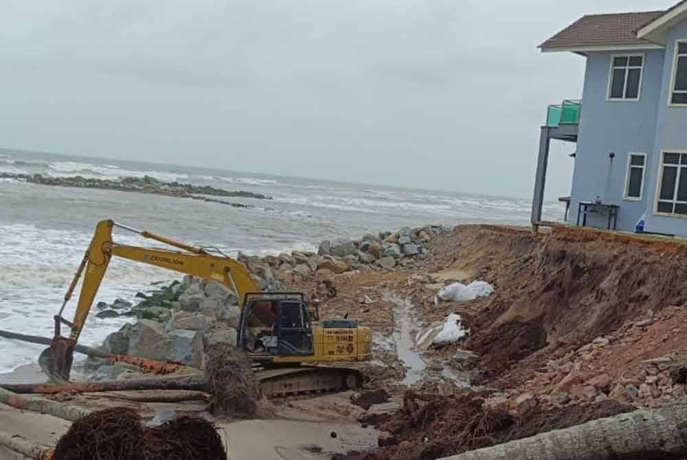 Jentera pengorek mula menambun tanah dan batu di kawasan rumah tersebut pada Sabtu. Gambar: Ihsan keluarga