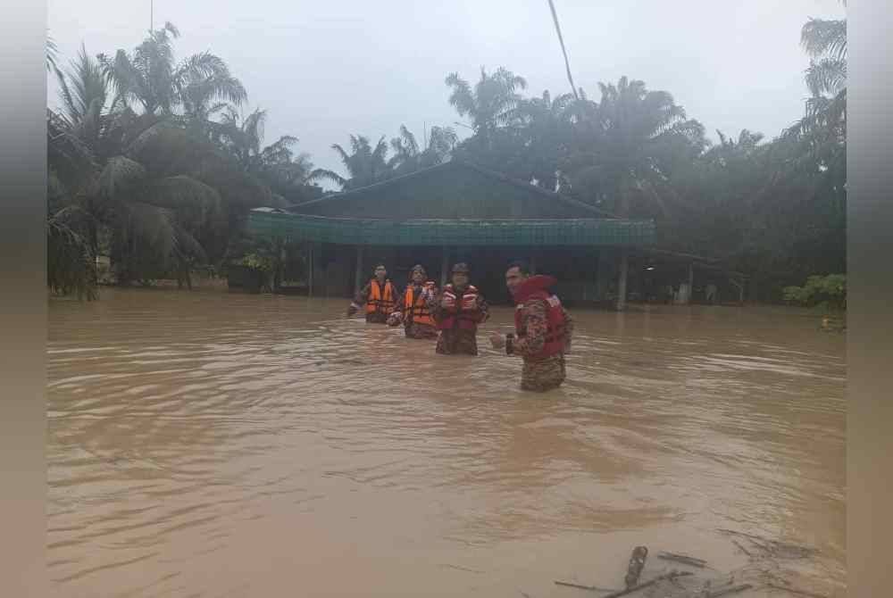 Anggota bomba membantu memindahkan mangsa banjir di Kampung Sri Gambut Pontian. - Foto JBPM