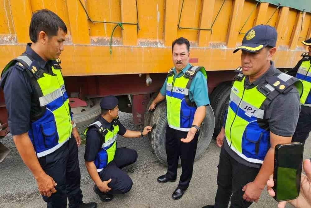 Muhammad Kifli (dua dari kanan) menunjukkan keadaan tayar lori yang dikesan telah botak dalam pemeriksaan Op Khas Lebih Muatan di JPJ Cawangan Taiping.