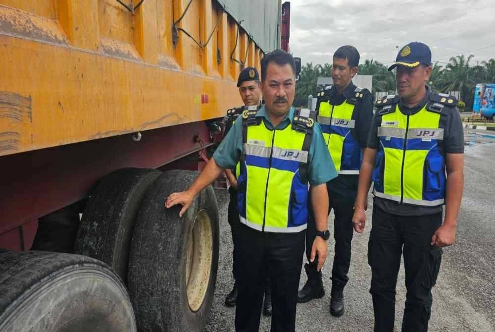 Muhammad Kifli menunjukkan keadaan tayar lori yang dikesan telah botak dalam pemeriksaan Op Khas Lebih Muatan di JPJ Cawangan Taiping.