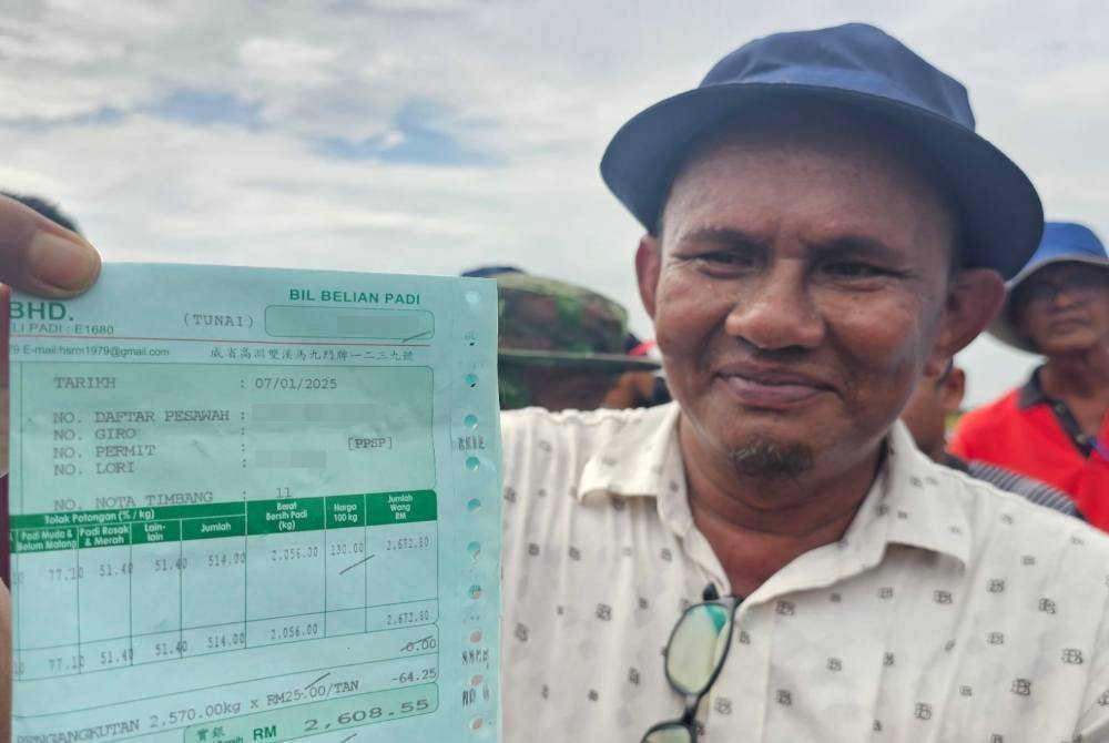 Azhar menunjukkan bil belian padi yang menunjukkan harga baru iaitu RM130 bagi 100kg yang diterima petani di daerah Kerian.