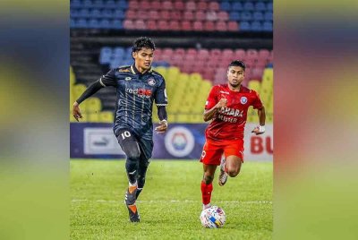 Shahrel Fikri (kiri) sandaran PDRM berdepan Kuching City di Selayang. Foto PDRM Football Club