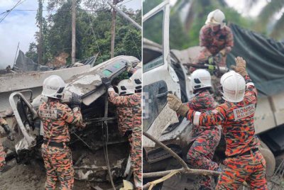Pasukan bomba mengeluarkan mangsa tersepit apabila lori membawa muatan pasir yang dipandunya terbabas di Kampung Menggaris, Kota Marudu.