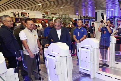 Saifuddin Nasution mencuba sistem kod QR semasa meninjau Gate Kod QR MyBorderPass dan Sistem Smart Q di Terminal 1, KLIA pada Sabtu.