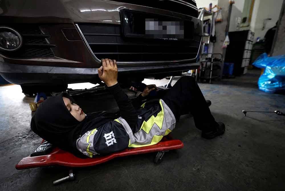 Khairin Qisstina melakukan kerja-kerja membaiki kereta ketika ditemui di MTH Autohaus & Accessories di Taman Pengkalan Jaya baru-baru ini. Foto Bernama