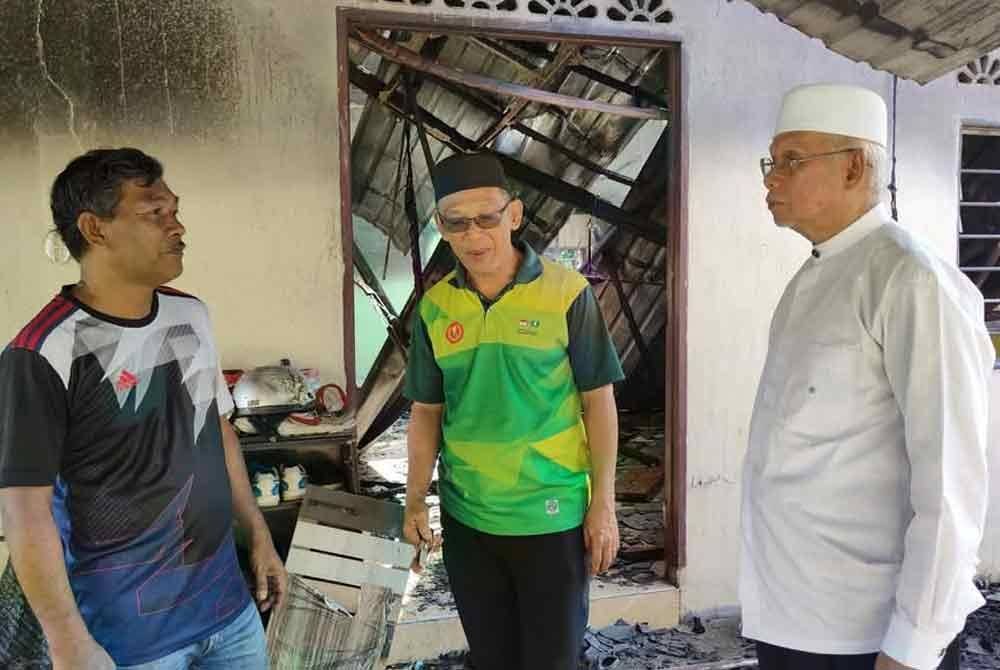 Ahli Dewan Undangan Negeri Kupang, Datuk Najmi Ahmad (kanan) ketika melawat rumah terbakar di DUN Kupang sebelum ini.