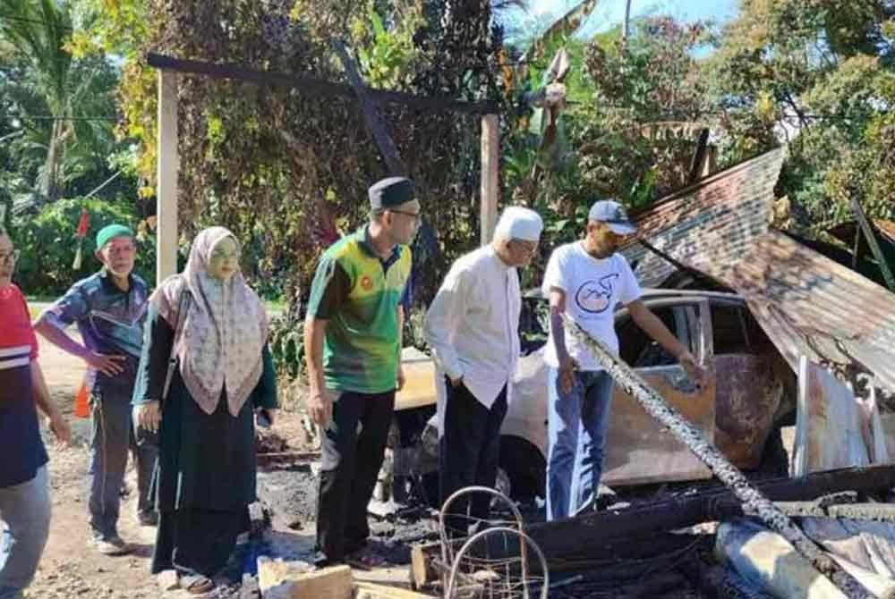 Ahli Dewan Undangan Negeri (ADUN) Kupang, Datuk Najmi Ahmad (dua dari kanan) melawat lokasi kejadian kebakaran pada Disember lepas.