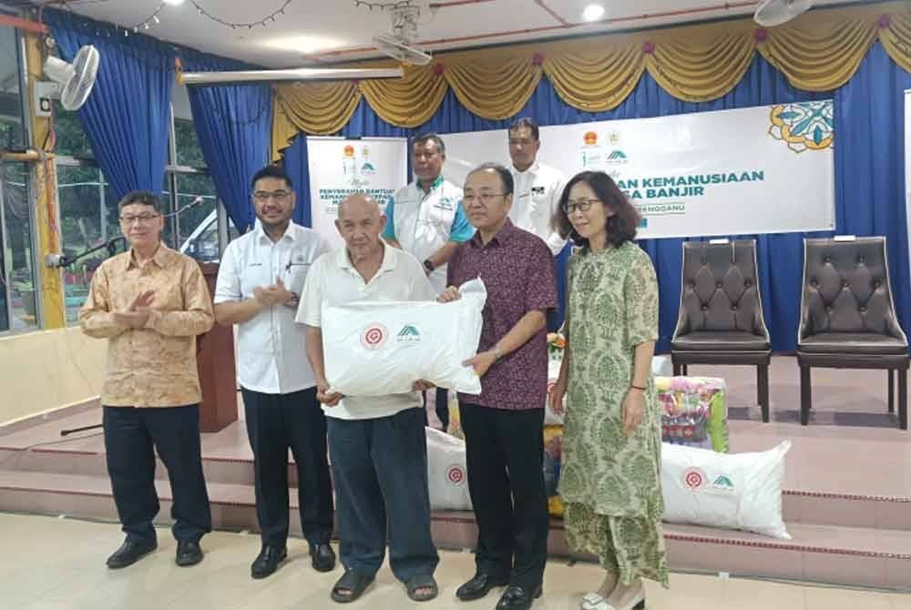 Yujing (dua dari kanan) menyampaikan sumbangan kepada mangsa banjir pada majlis penyerahan bantuan kemanusiaan di SK Pulau Rusa pada Ahad.