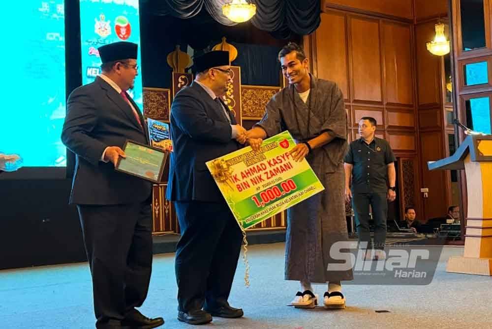 Dr Mohamed Fadzli (tengah) menyampaikan Anugerah Khas Anak Muda Kelantan kepada Nik Ahmad Kasyfi (kanan). - FOTO SINAR HARIAN/ADILA SHARINNI WAHID.