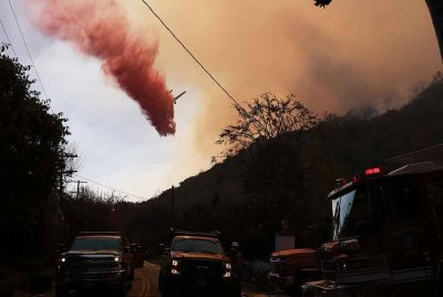 Sebuah kapal terbang memadam kebakaran bagi menghalang api daripada merebak lebih jauh di bukit Mandeville Canyon di Los Angeles, California. Foto Xinhua