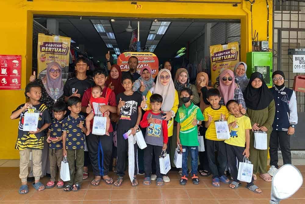 Norhaslinda (tengah) bersama kanak-kanak yang menerima bantuan persekolahan.