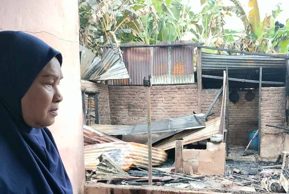 Nor Maidah melihat rumahnya yang hangus dalam kebakaran di Kampung Charuk Kapas, Kupang, Baling.