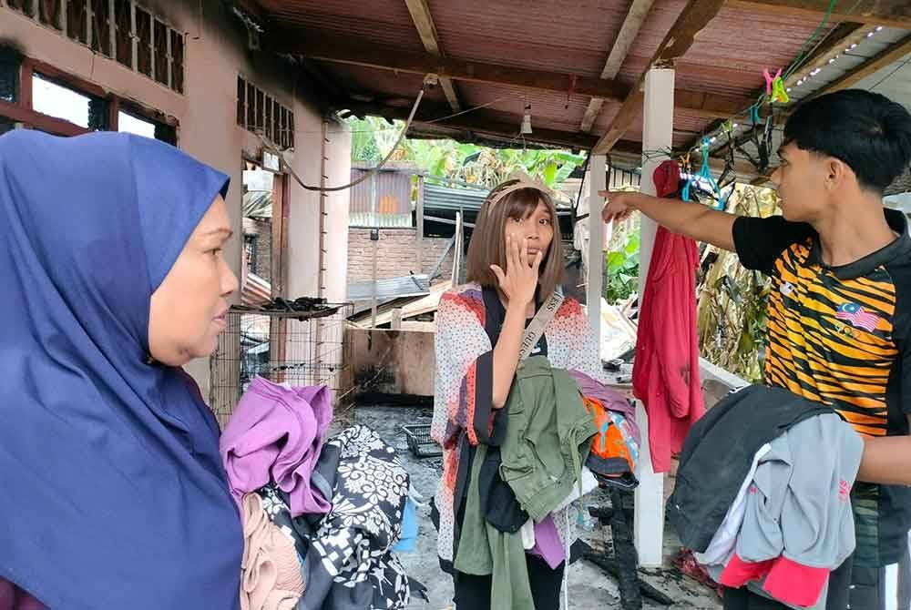 Muhammad Hakimi (kanan) dan Nor Maidah (kiri) menunjukkan kebakaran di rumah mereka yang berlaku pada Ahad.