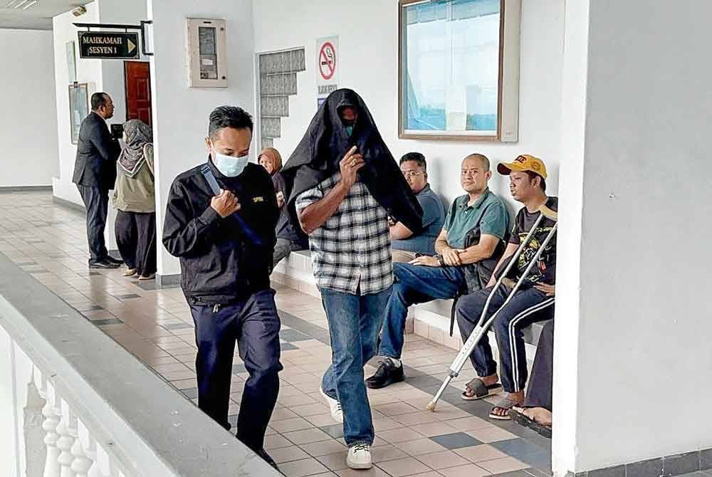 Zainal Abidin (dua dari kiri) ketika dibawa keluar dari Mahkamah Sesyen di sini pada Isnin.