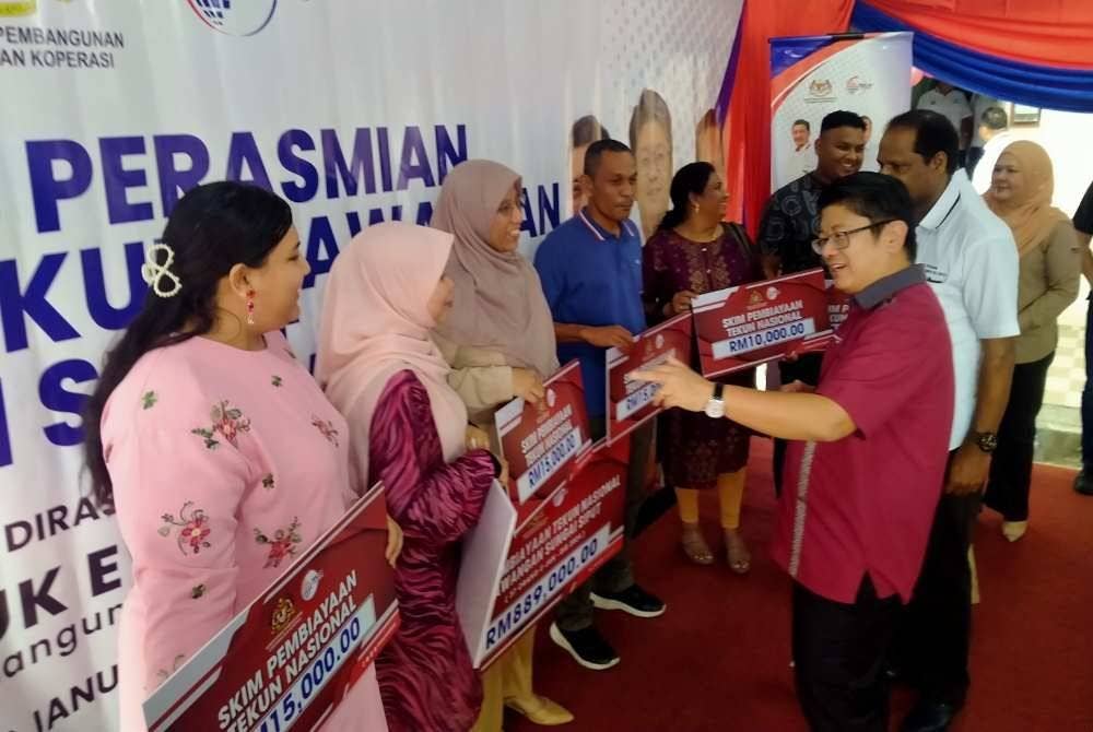 Ewon (kanan) beramah mesra bersama penerima pinjaman Tekun Nasional selepas menyempurnakan Majlis Perasmian Pejabat Tekun Nasional Cawangan Sungai Siput di Medan Pesona di sini pada Isnin.