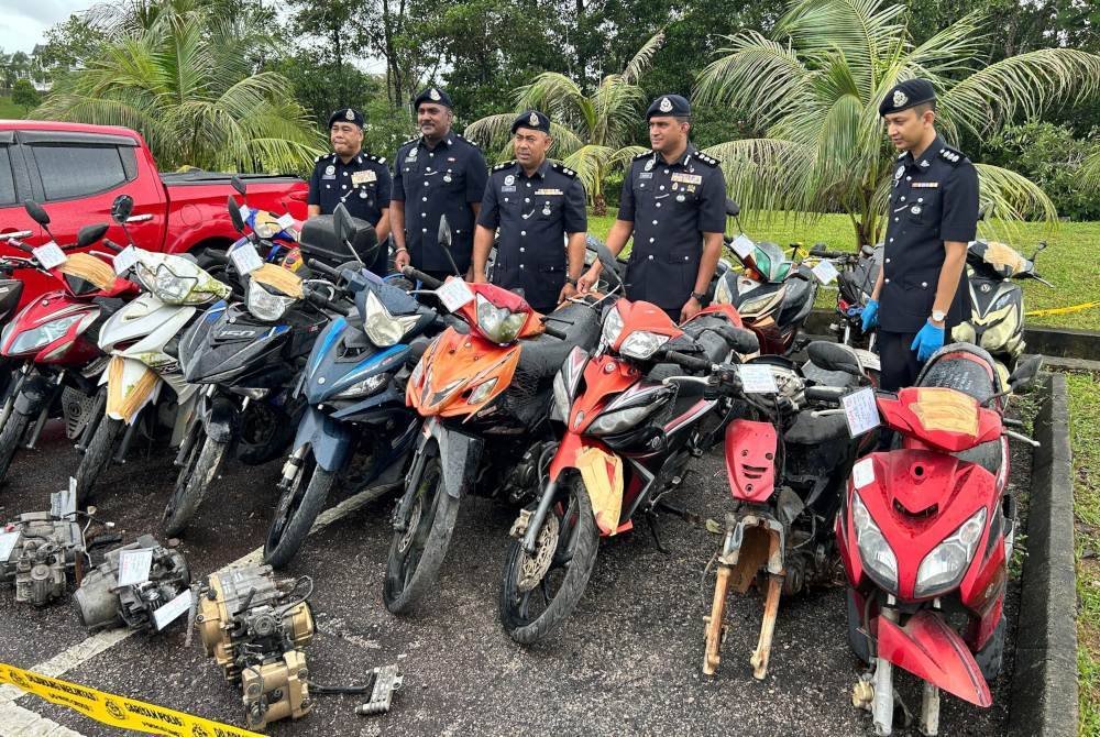 Kumarasan (dua dari kanan) bersama sebahagian motosikal yang dirampas.