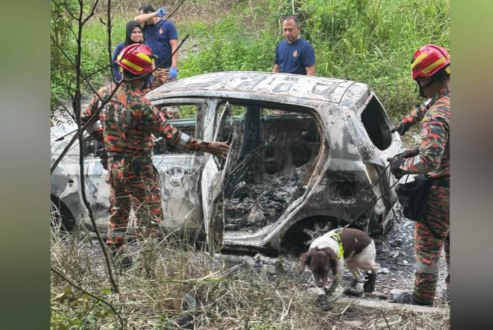 Anggota bomba melakukan siasatan bagi mengetahui punca kebakaran sebuah kereta jenis Perodua Axia dibakar di kawasan letak kereta Seksyen U4, Shah Alam, Selangor pada Ahad. Foto PDRM