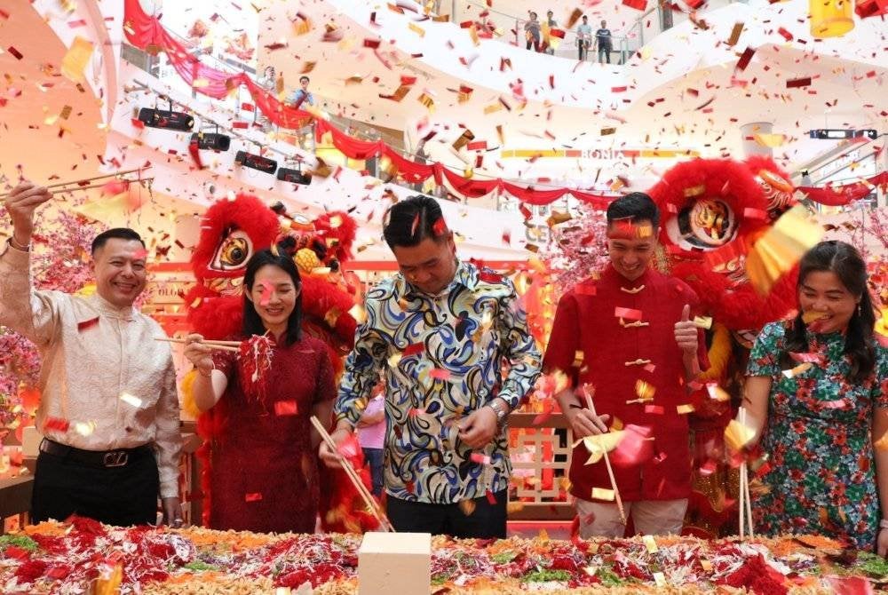 Tetamu kehormat sedang menyempurnakan tradisi kaum Cina “Lou Sang” sebagai simbol kemakmuran dan permulaan keberuntungan.